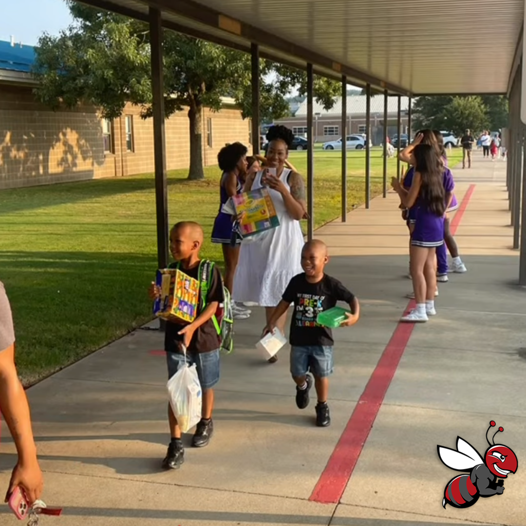 Students walking toward their school smiling with school supplies