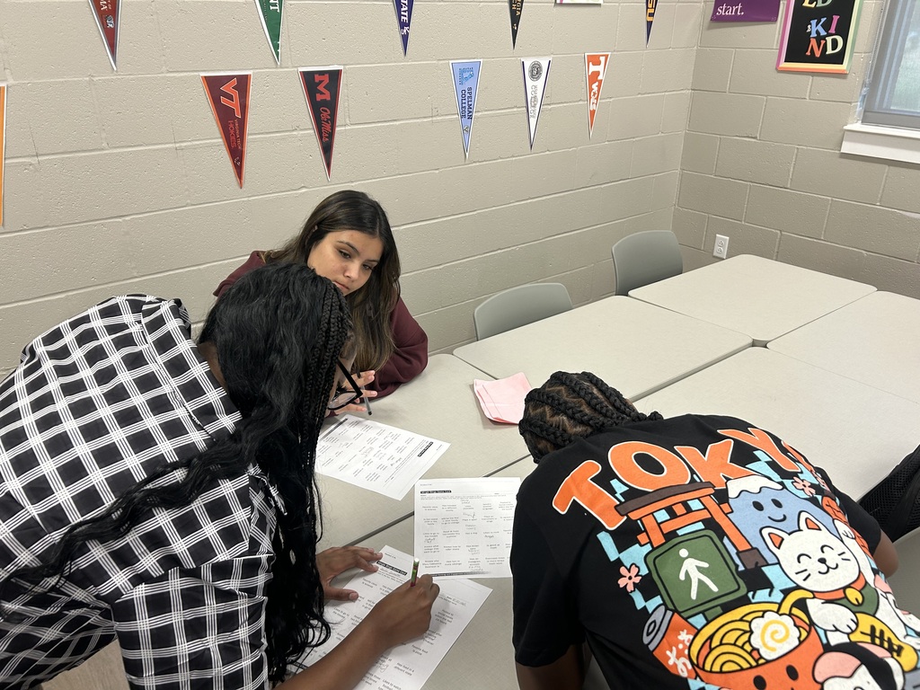 Students around desks writing on paper