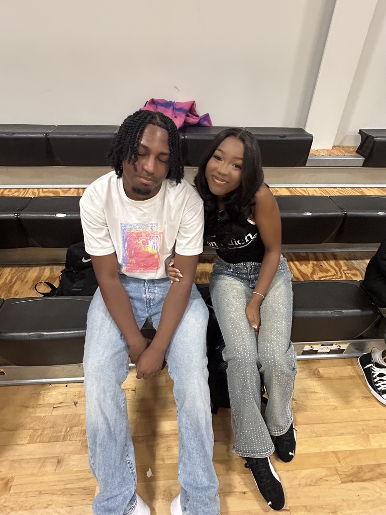 Students sitting on bleachers posing for photo