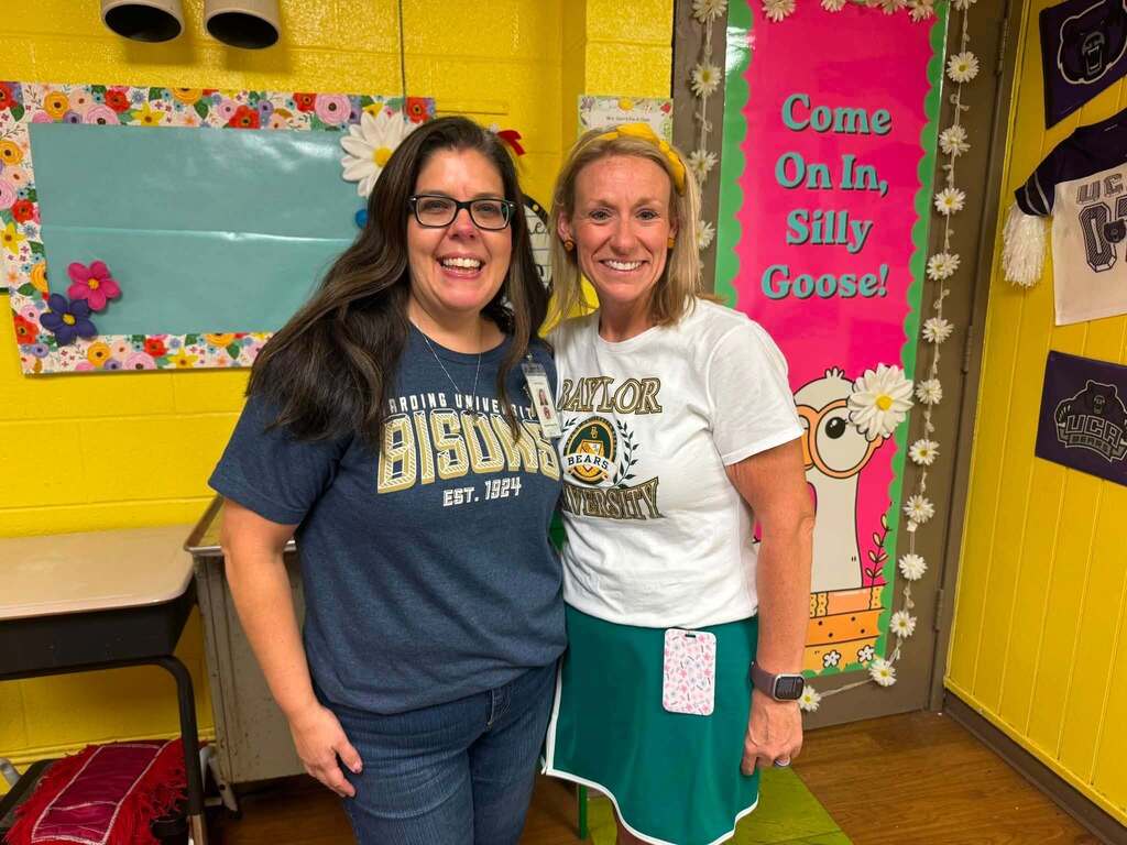Two people wearing college shirts