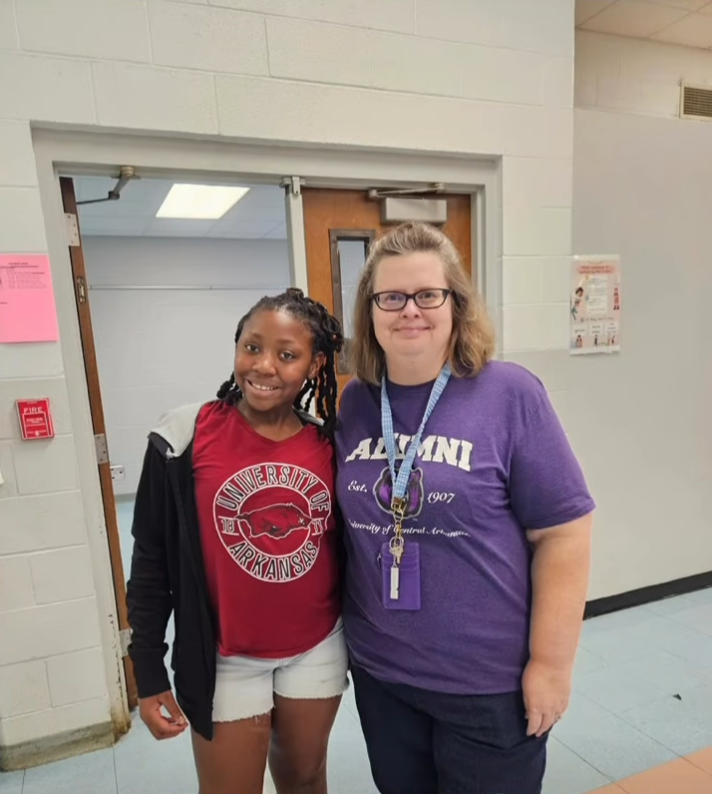 Two people wearing college shirts