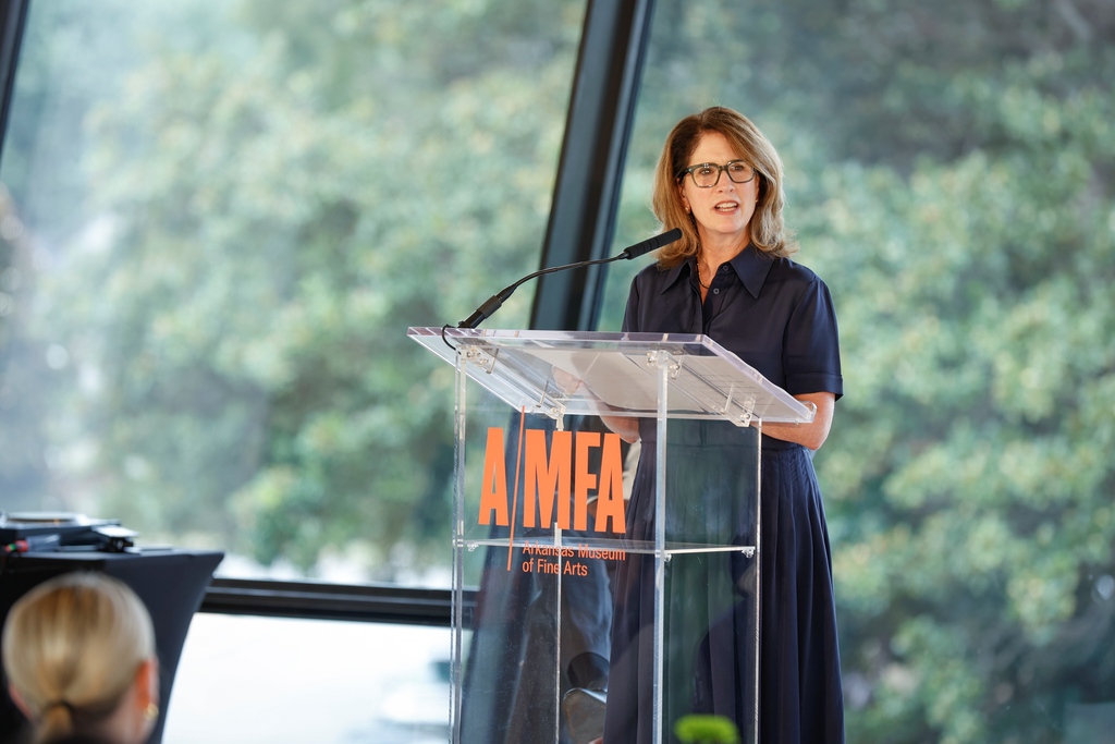 a woman at a podium. The podium says AMFA