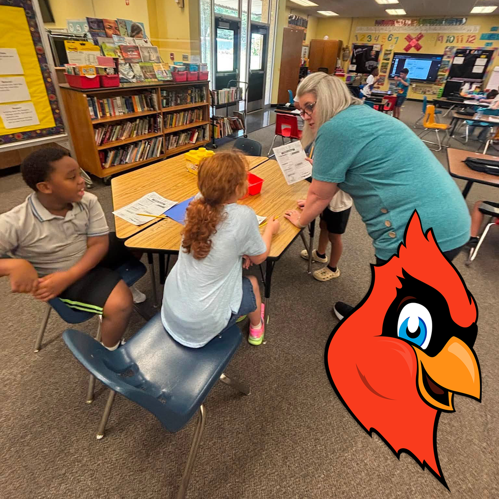 A teacher leaning over a table to teach her students