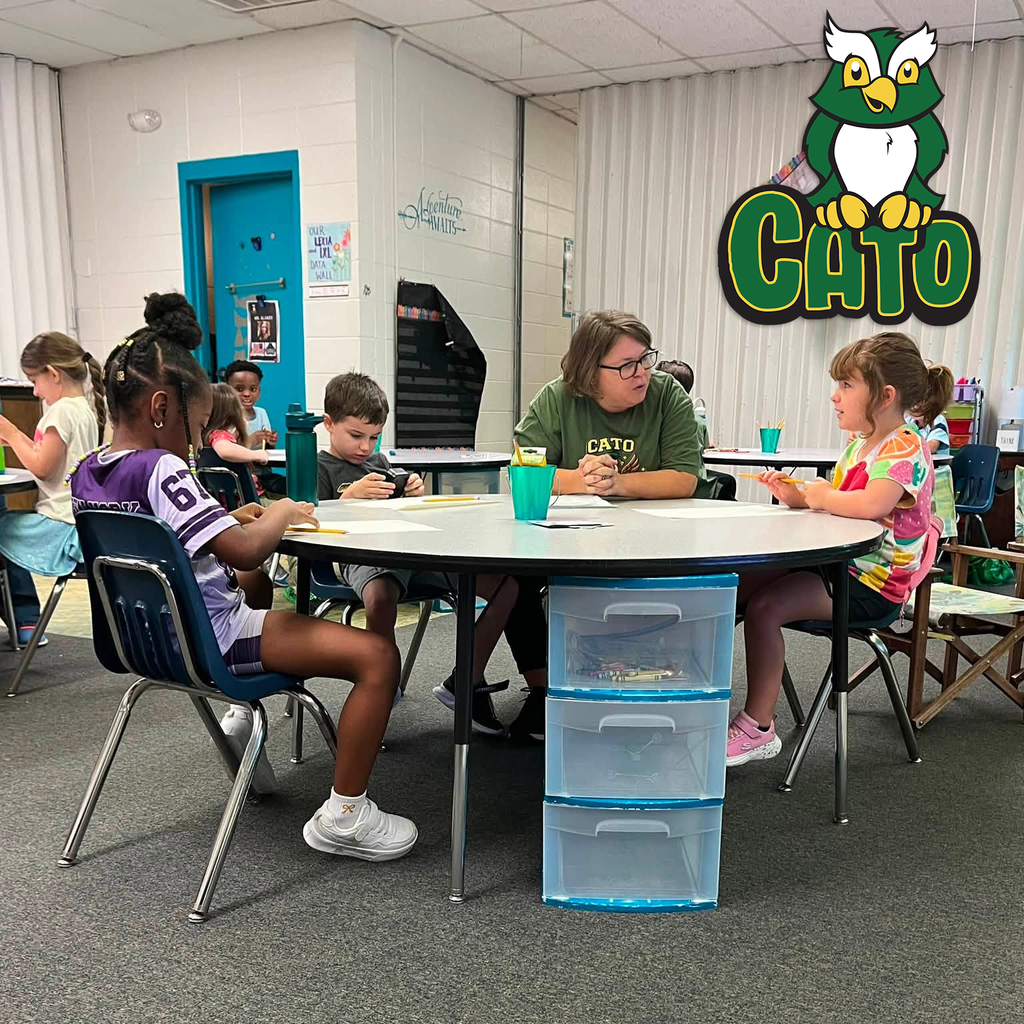 students learning at a table with their teacher