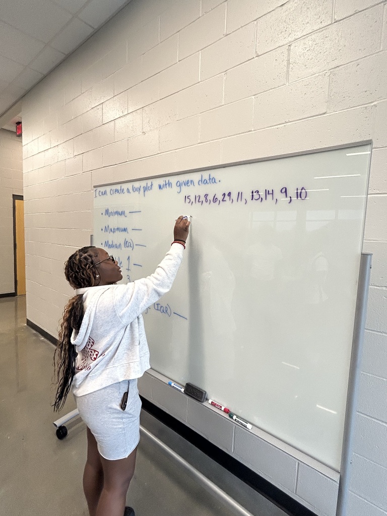 Student writing a data set on a white board