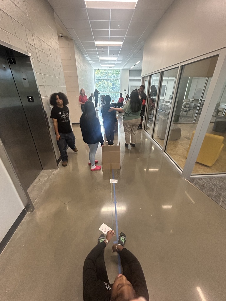 Students holding boxes and string to understand box plots