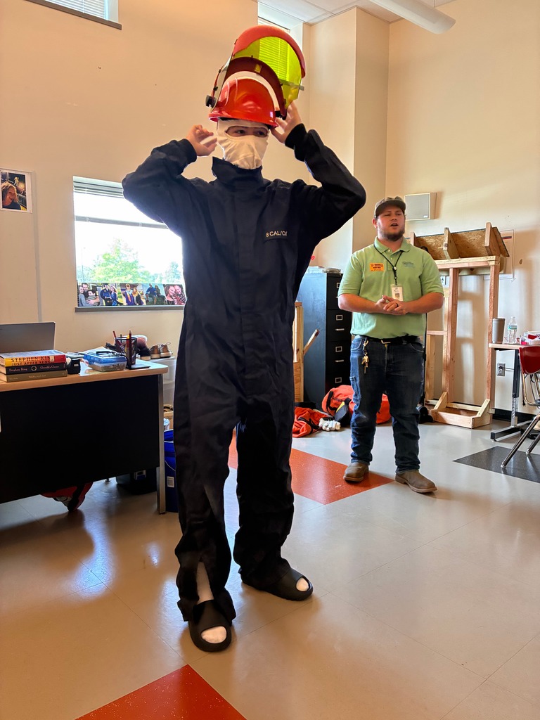 A student in PPE with an instructor classroom guest from Central Arkansas Water behind him.