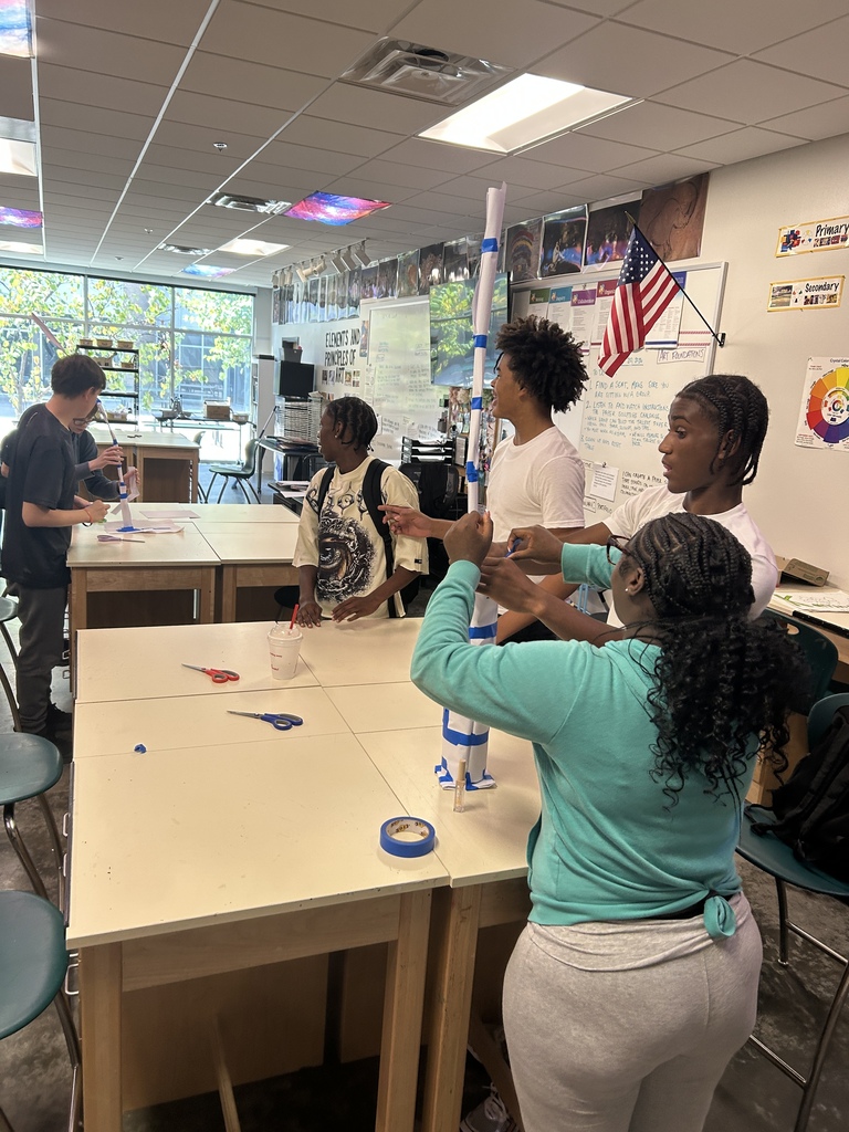 Students working together in art class to build paper sculptures