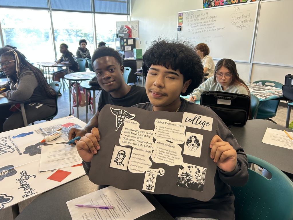 Student holding up his vision board project
