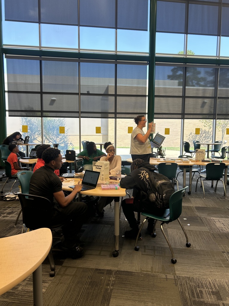 Media specialist speaking to the students at tables in the library