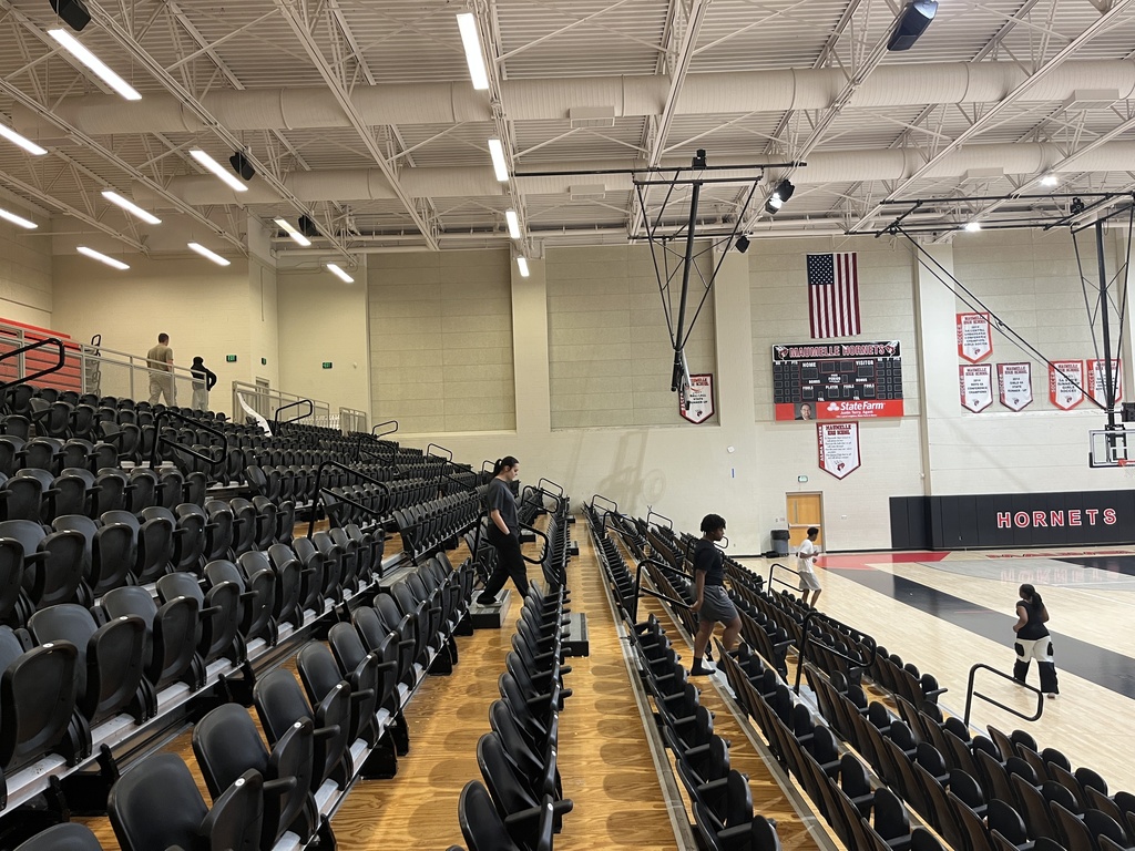 Students climbing up steps in a "Hornets" auditorium