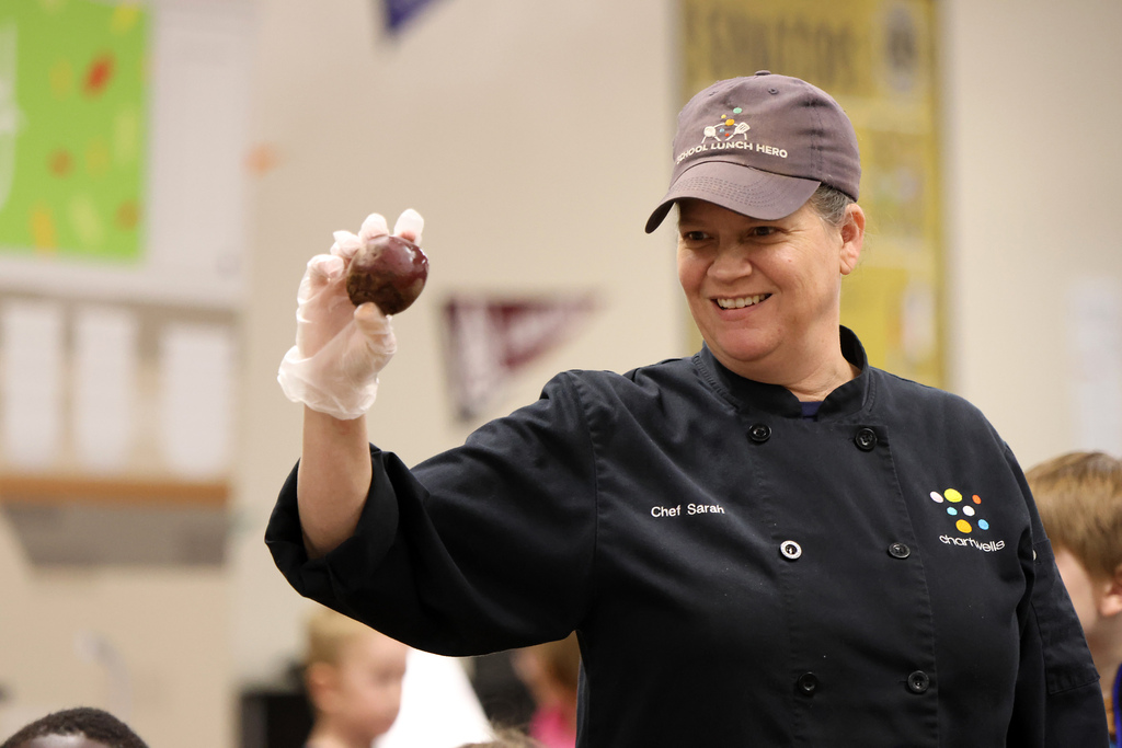 Chef Sarah holding a beet in her gloved hand