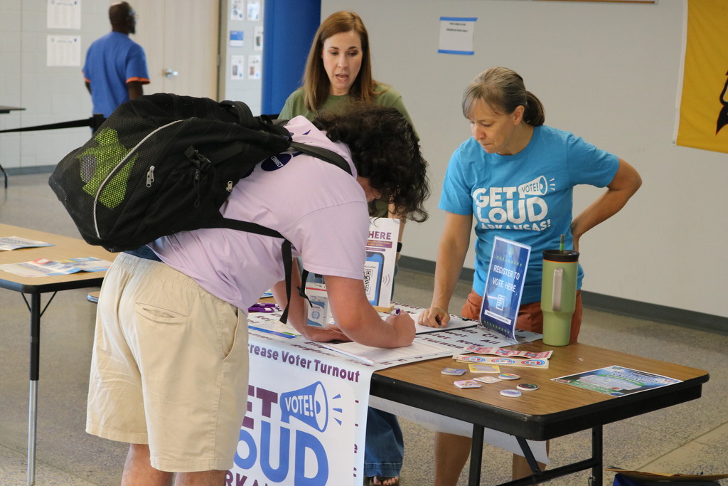 student looking at voter registration papers with adults