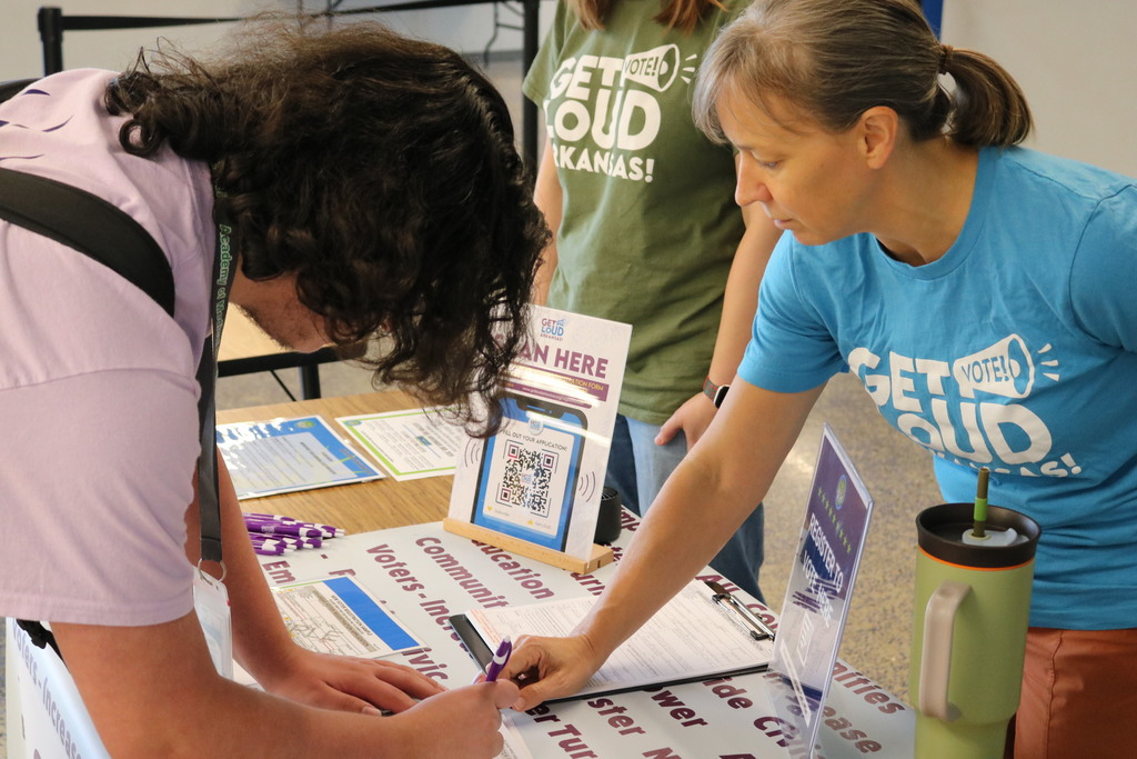 student looking at voter registration papers with adults