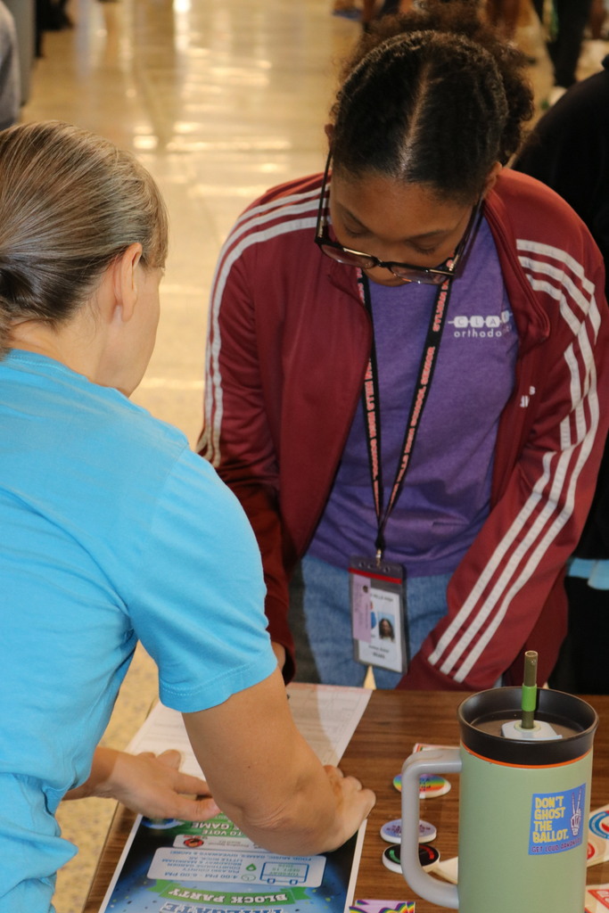student looking at voter registration papers with adults