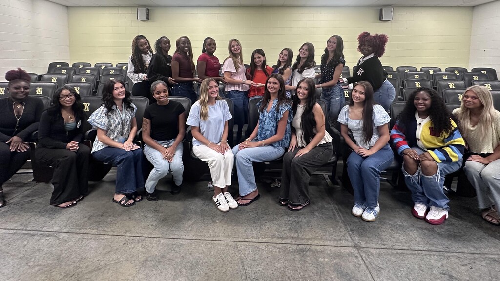 Joe T. Robinson High Homecoming Court. 20 women are sitting or standing in a room.