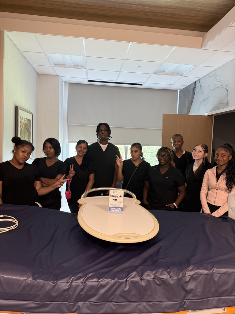 Group photo of students who are around a health care bed