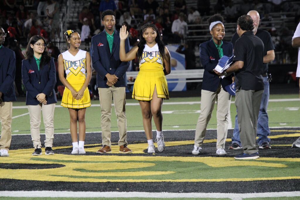 A student in the Lexicon Academy of Advanced Manufacturing and Construction waves to the crowd while being recognized during Lexicon Academy Night at Mills University Studies High School.