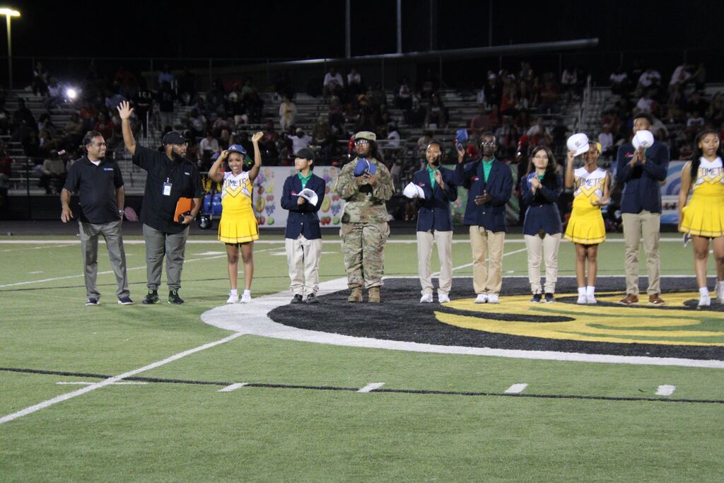 Students, educators, military representatives, and industry partners line up at midfield during the first-ever Lexicon Academy Night recognition ceremony at Mills University Studies High School.