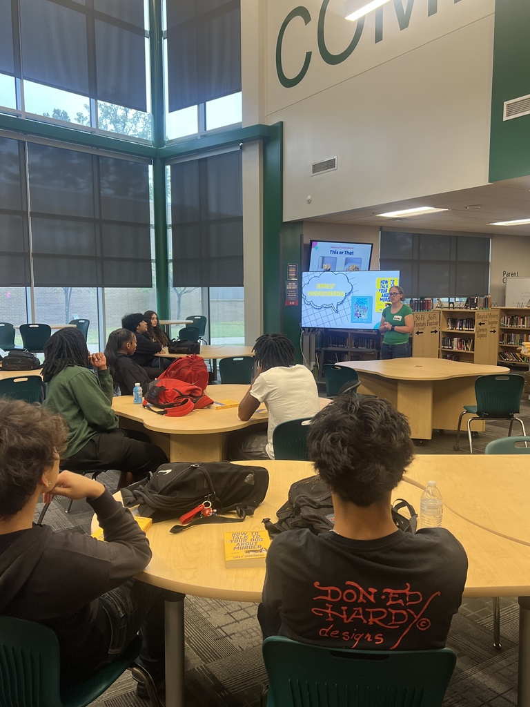Students are around tables listening to guest speaker