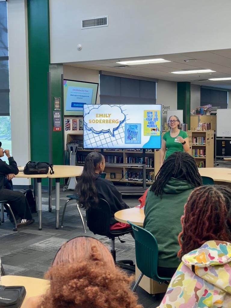 Students in a library listening to guest speaker