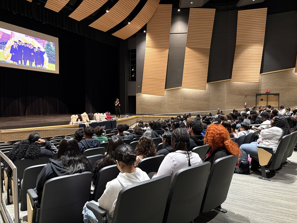 Students in an auditorium listening to guest speaker