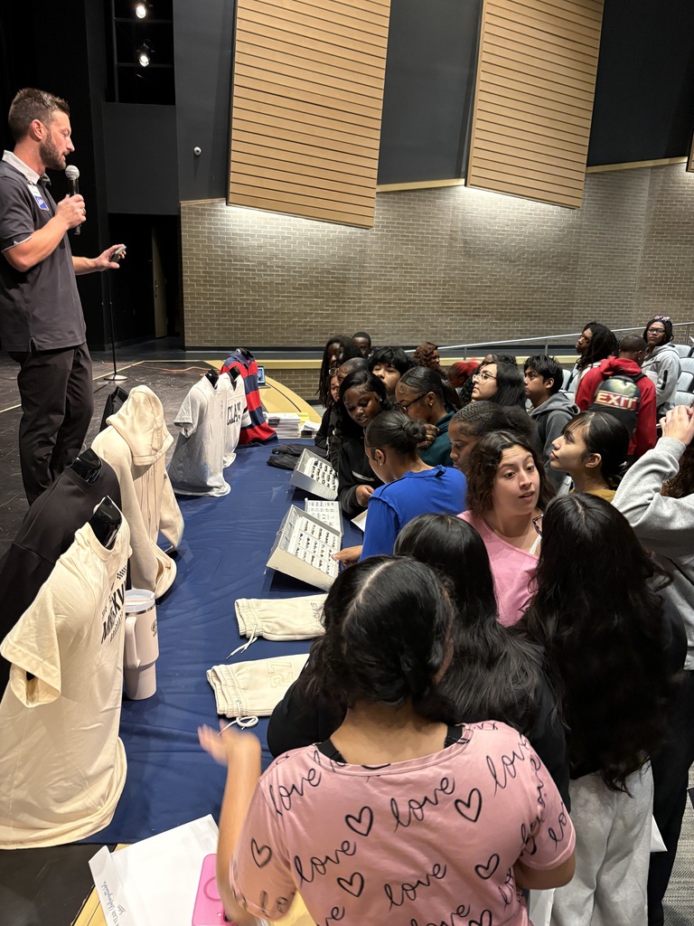 Students around a stage looking at senior materials