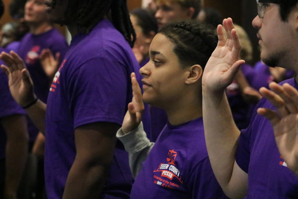 Student raising their hands in oath while wearing Teen Court PCSSD shirts