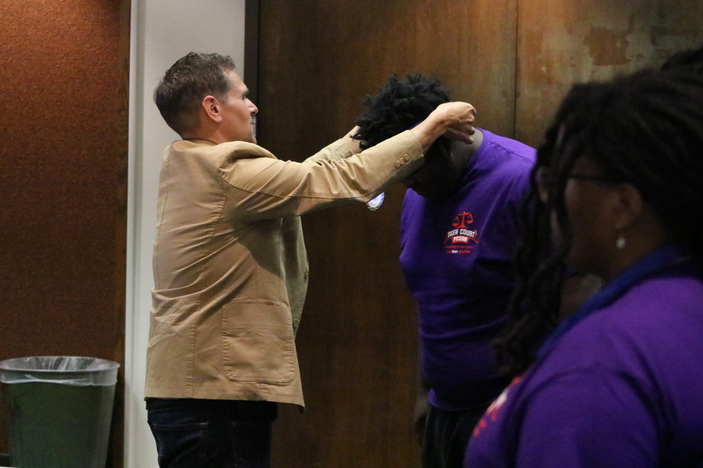 An administrator gives a medal to a student