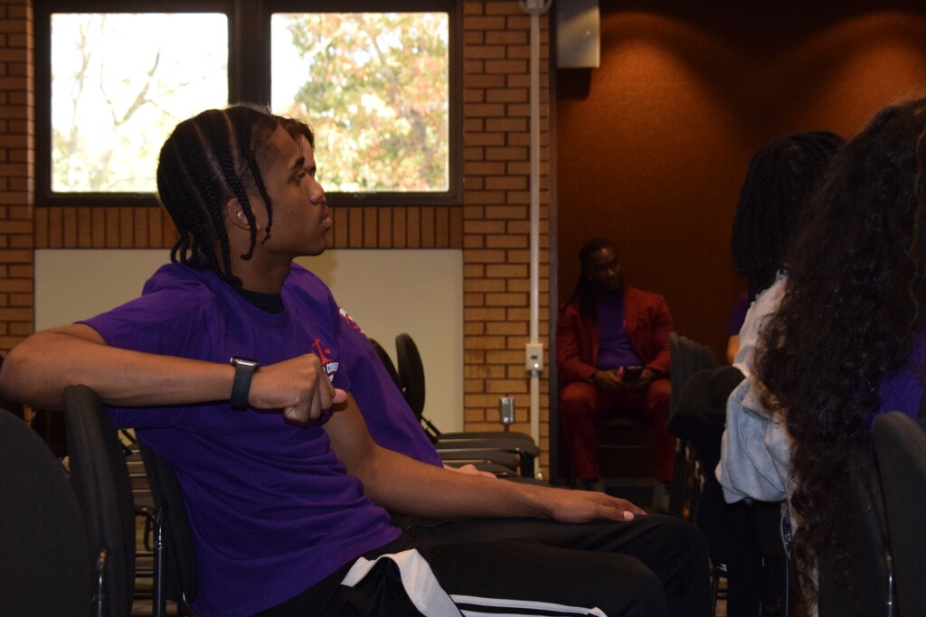 A sitting student listening intently to a speaker