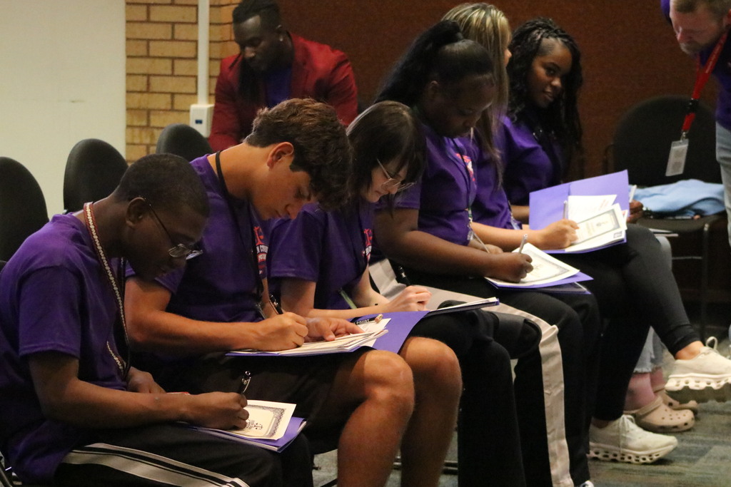 A row of students sign an oath of confidentiality