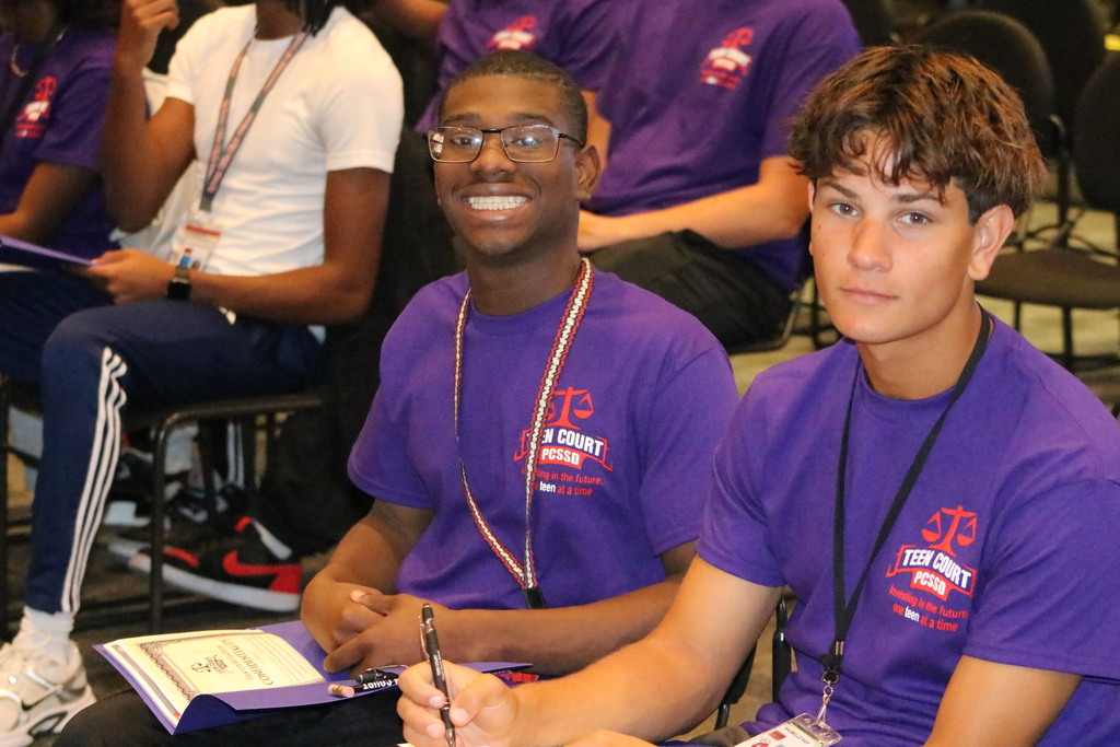 Two Teen Court students sit and look at the camera