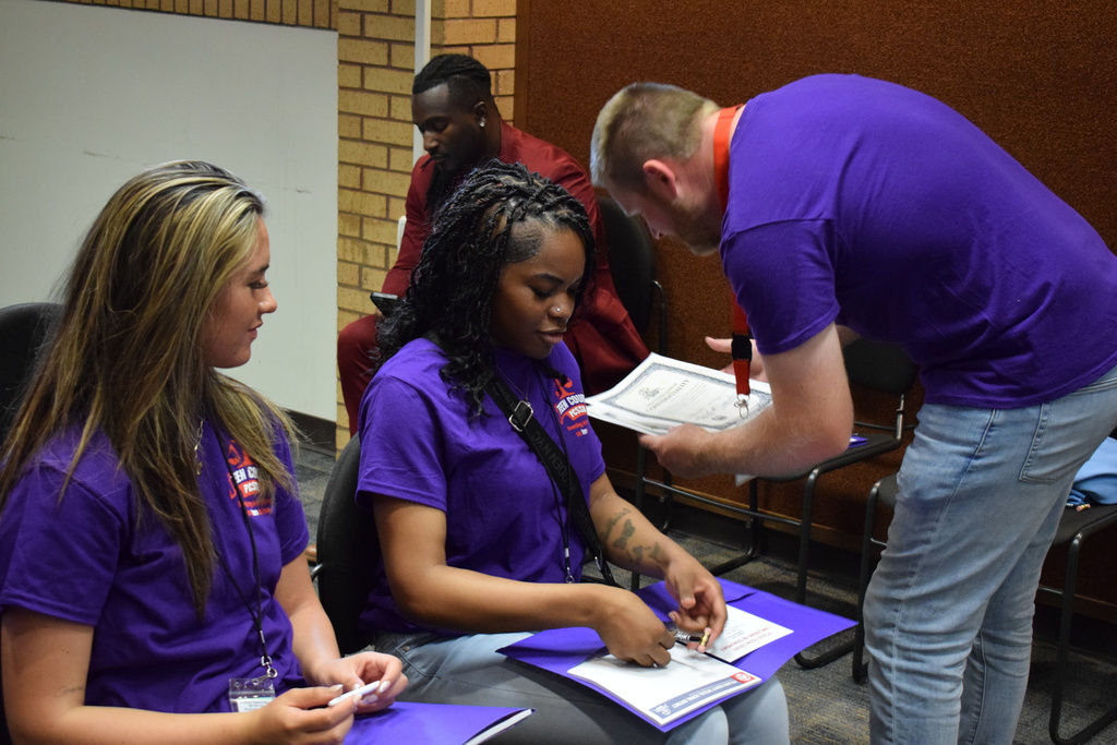 A teacher collects oaths of confidentiality from teen court students