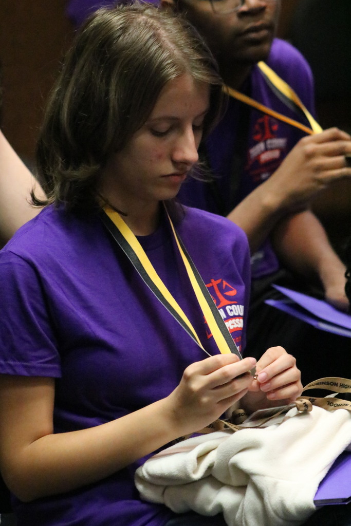 Students look down at their recently received medals
