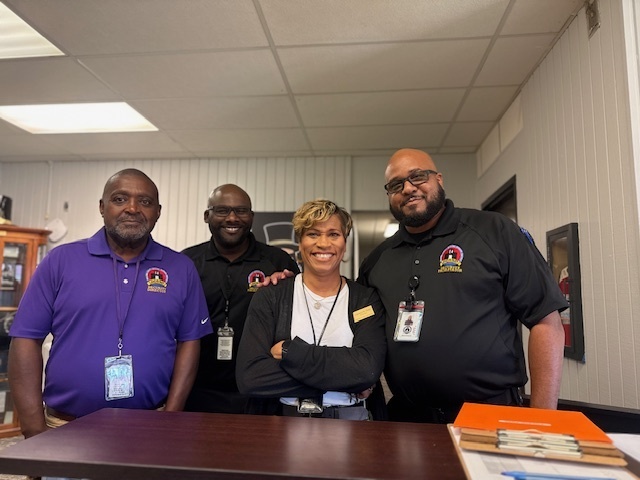 Photo of four people, including Robinson High School Principal Isaac and members of the PCSSD security team, standing together following an active shooter drill. The team participated in emergency preparedness training focused on campus safety.