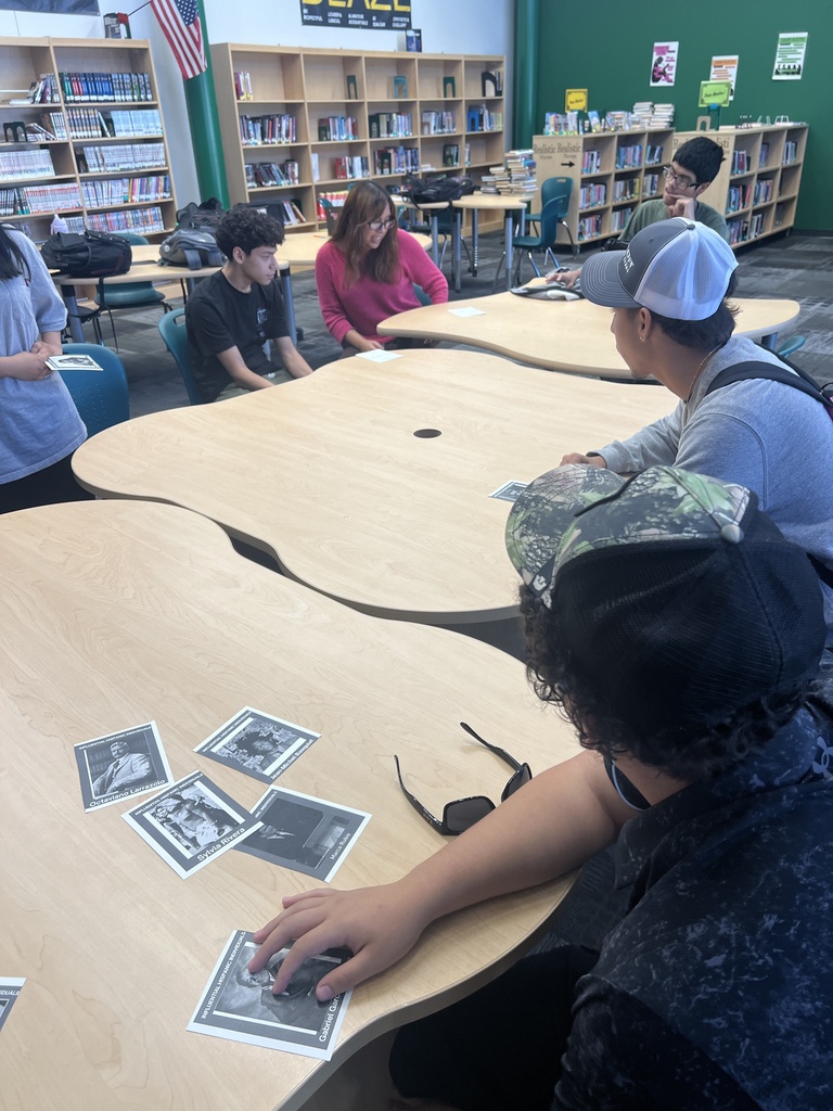 Students working in groups around tables
