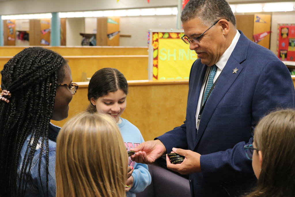 Sheriff Eric Higgins handing out badge fidgets to students