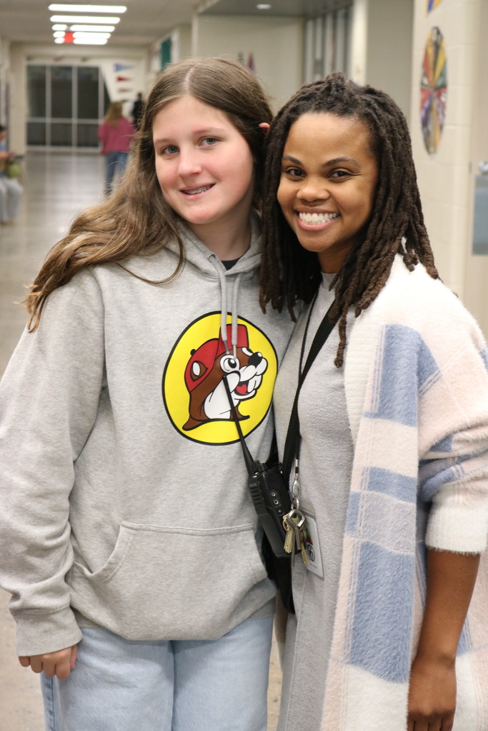 a principal and student standing together smiling