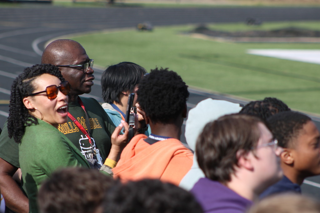 Students and teachers look on as a helicopter takes off.