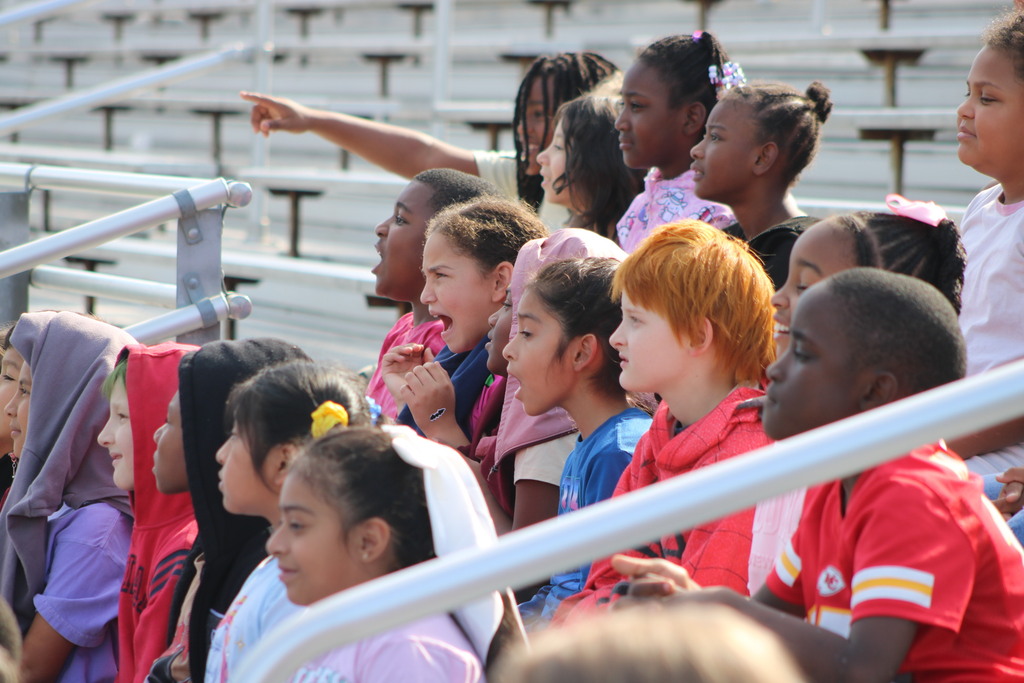 Excited students point  from bleachers