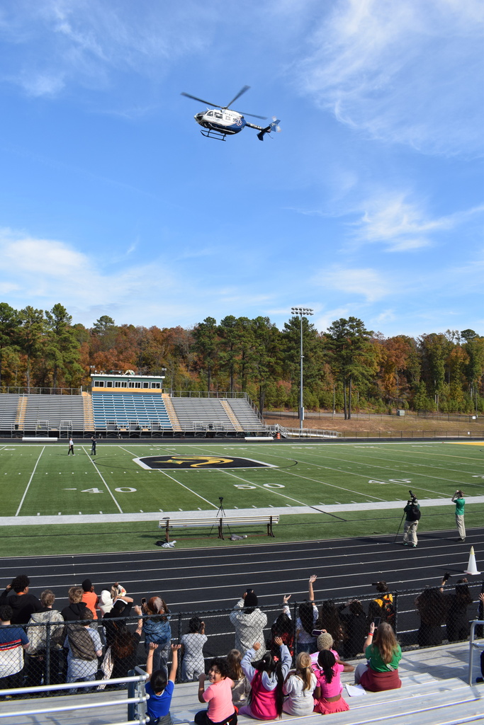 Students wave at a helicopter from below