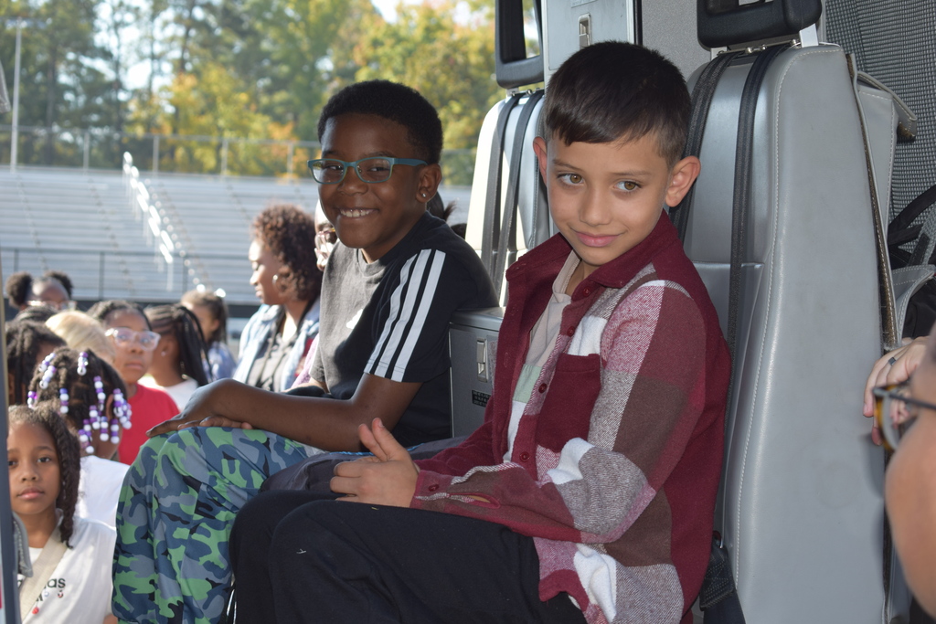 Students smile and sit inside a helicopter