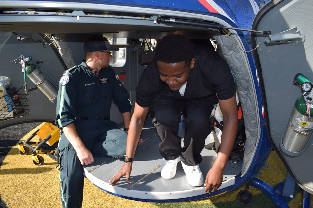 student clambers out of a medflight helicopter
