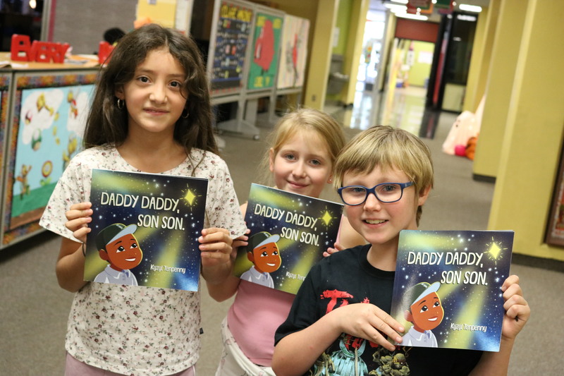 Landmark Elementary students hold up "Daddy Daddy, Son Son"