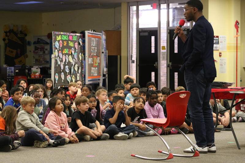 Kyzyl Tenpenny reading his book "Daddy Daddy, Son Son" to students inside Landmark Elementary