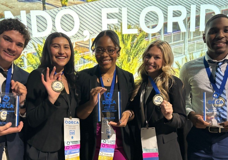 Five students holding their DECA awards at Orlando, Florida