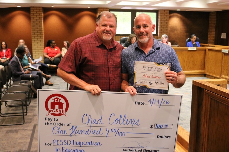 Jeff Sen and a teacher hold a check and inspiration in education award