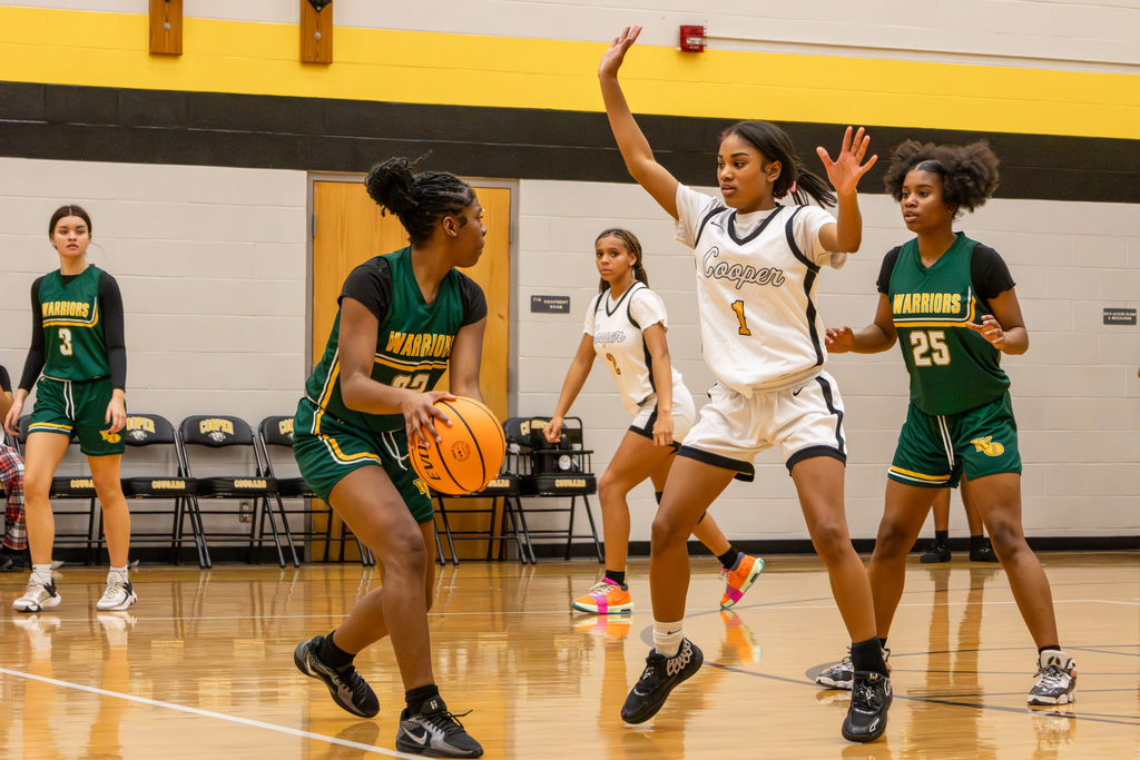 Western Oaks player looking to pass, guarded by Cooper player