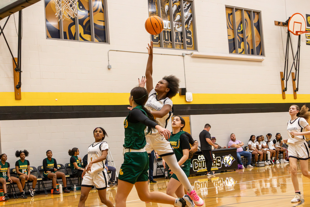 Cooper player jumping over Western Oaks defender for layup