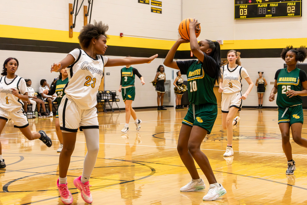 Western Oaks player taking a shot from high key, defended by Cooper player